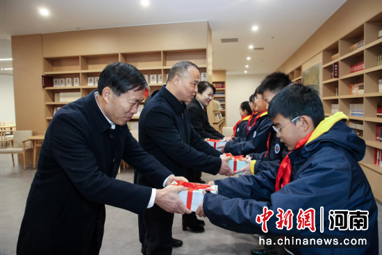 图为河南省法院、省司法厅向师生代表赠送传统法治文化漫画读本《跨越千年的对话》